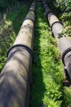 Two large black water pipes, converging in distance. Stock Photos