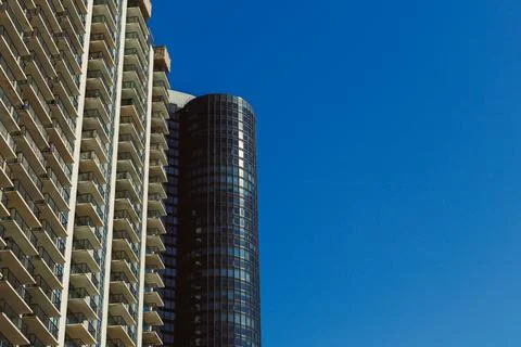 Two large buildings stand side by side in a city. One building has many balco Foto stock