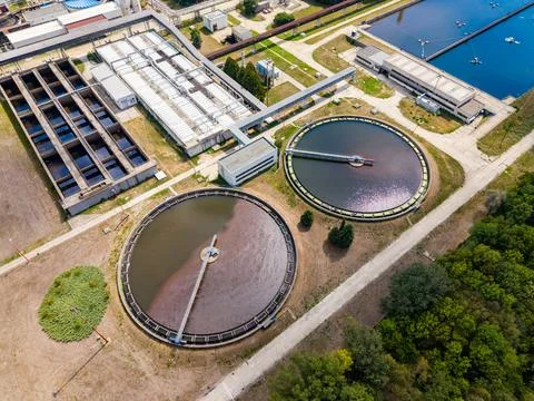 Two large circular tanks are part of a water treatment facility. Surrounding  Stock Photos
