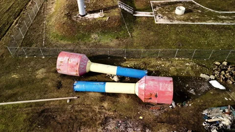 Two large, colorful industrial structures with red and blue sections lie on the 스톡 동영상 332893983