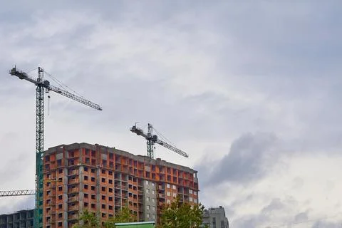 Two large construction high rise cranes, cloudy sky Stock Photos