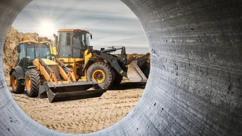 Two large construction vehicles are positioned at a rental site, highlighting Stock Photos