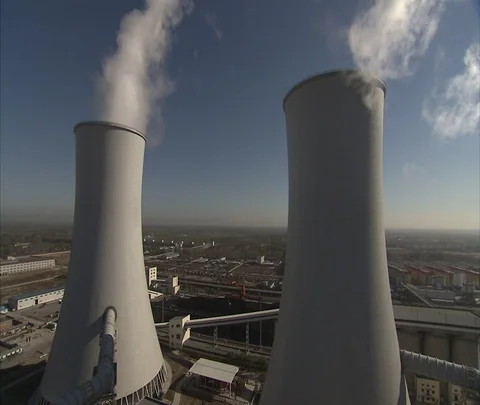 Two large cooling towers, one is spewing plumes of smoke Stock Footage 86745996