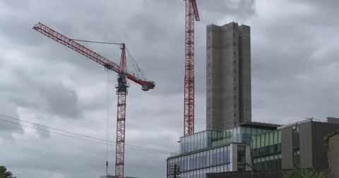 Two large cranes next to tower skyscraper building under construction Stock Footage 340412264
