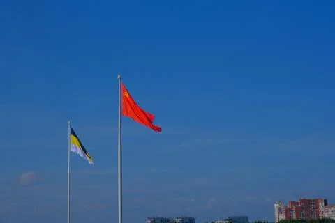 Two large flagpoles with the flags of the Soviet Union and the Russian Empire Stock Photos