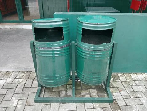 Two large green garbage bins on the front store. Foto stock