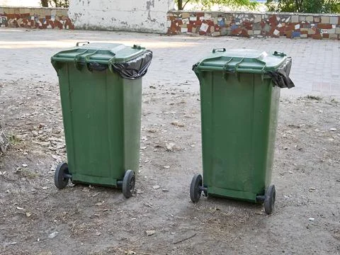 Two large green garbage containers on the street. Ecology and cleanliness in the Stock Photos