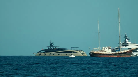 Two large luxury yachts navigating the deep blue ocean on a sunny day, Stock Footage 339804866