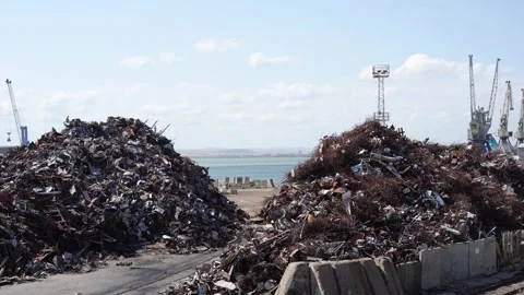 Two large piles of metal scrap sit near a seaport 스톡 동영상 315443329