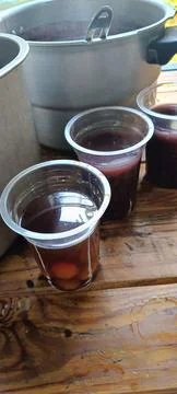Two large pots and two plastic cups filled with delicious food Stock Photos