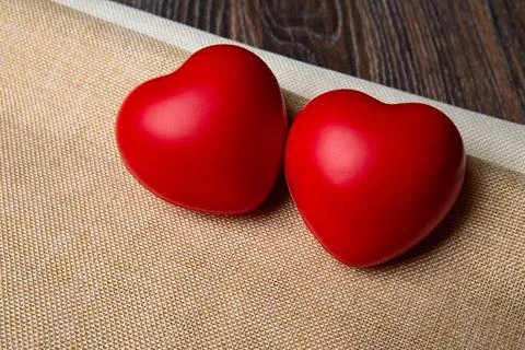 Two large red hearts on a textile background close up 库存照片