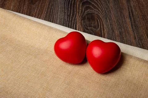 Two large red hearts on a textile background close up 库存照片