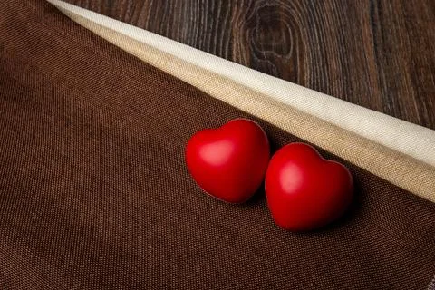 Two large red hearts on a textile background close up Stock Photos