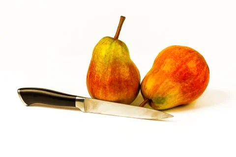 Two large ripe pears and a knife on a white background Stock Photos