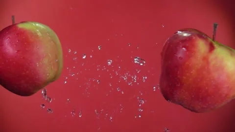 Two large ripe red apples are flying towards each other on the red background Stock Footage 234139840