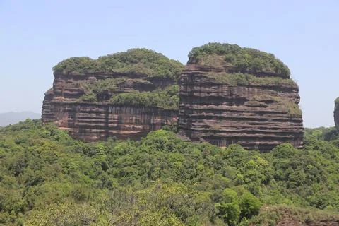 Two large rock formations with green trees growing on them Stock Photos