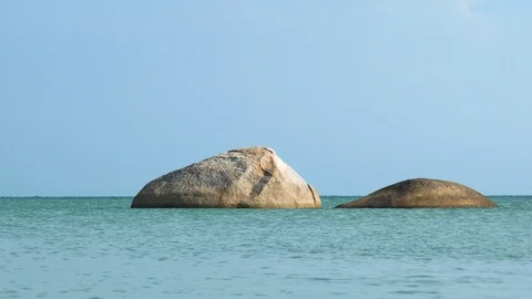 Two large rocks in the calm turquoise ocean Stock Footage 94106551