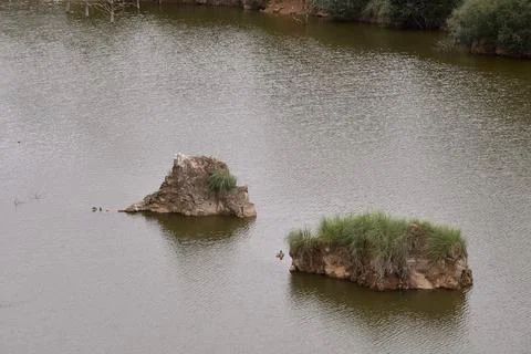Two large rocks emerging in a lake Stock Photos