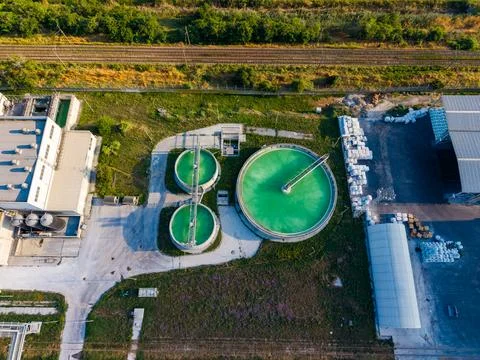 Two large round tanks filled with bright green liquid are part of a water tre Stock Photos