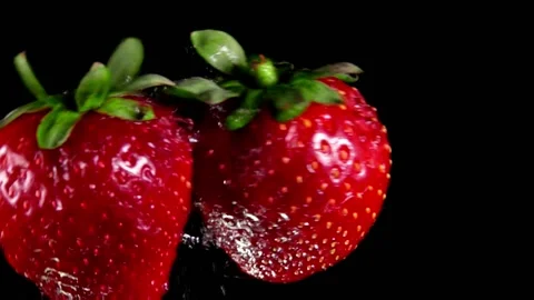Two large strawberries are colliding on the black background Video stock 136553109