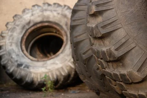 Two large, used tires with deep treads, one in focus in the foreground and an Stock Photos