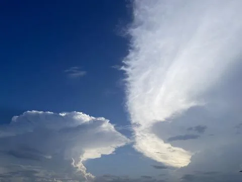 Two Large White Cumulus Clouds Forming In Blue Sky Horizontal Foto stock