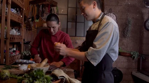 Two Latino restaurant workers talking while working in a kitchen together Stock Footage 126503756