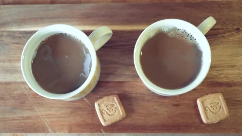 Two lattes served in two cups on a kitchen wood with two cookies by their side 스톡 동영상 130867063