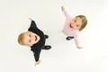 The two laugh children stand on the white background. View from above Photo