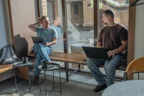 Two laughing It Software engineers working on project and programming in coffee Stock-Fotos