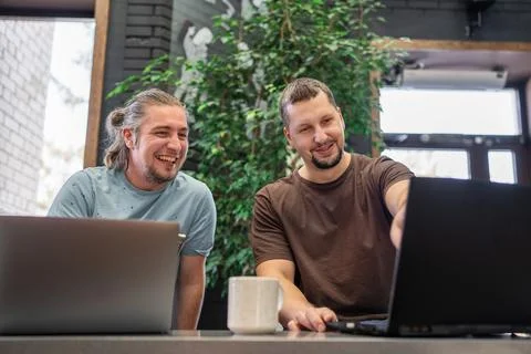 Two laughing It Software engineers working on project and programming in coffee Stock-Fotos