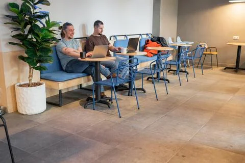Two laughing It Software engineers working on project and programming in coffee Stock-Fotos