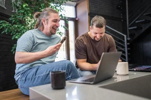 Two laughing It Software engineers working on project and programming in coffee 库存照片