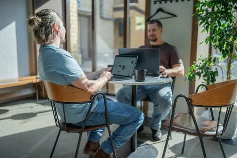 Two laughing It Software engineers working on project and programming in coffee Stock-Fotos