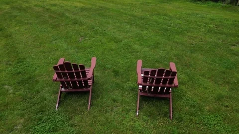 Two lawn chairs in front of house (flying above pair sitting seat deck chair) Video stock 278273669