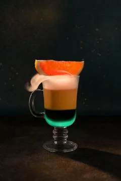 Two-layer coffee cocktail mint and red orange. Cold smoke leaks out. Stock Photos