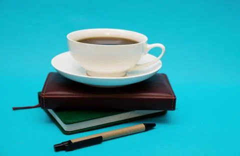 Two leather-bound notebooks lie on top of each other on a blue background. Stock Photos