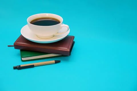 Two leather-bound notebooks lie on top of each other on a blue background. Stock Photos