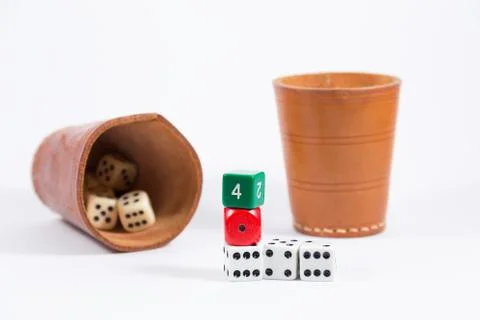 Two leather cups filled with dice and three colored dice isolated on white Stock Photos
