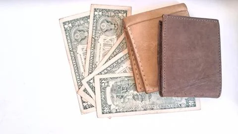 Two leather wallets resting on top of American paper currency Stock Photos