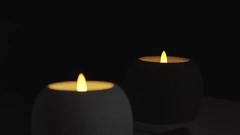 Two Led Candle On Black Background Round White and Dark Body Pulsing Light Stock Footage 324848537