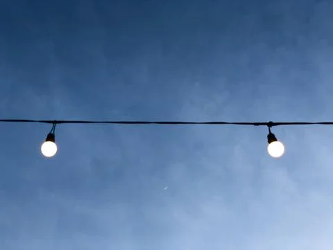 Two Led Light Bulb on the wire with blue cloudy sky Stock Photos