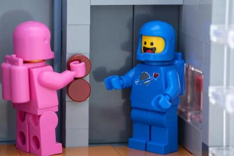 Two Lego astronauts waiting at an elevator Stock Photos