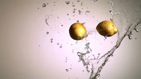Two lemons colliding with a water splash in midair Stock Footage 327789700
