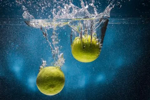Two lemons fall into the water Stock Photos
