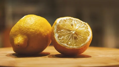 Two lemons lie on a cutting board. One whole and the other cut in half 스톡 동영상 161691205