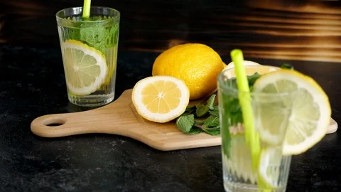 Two lemons, one of them cut in two, on a wooden board Stock Footage 89343874