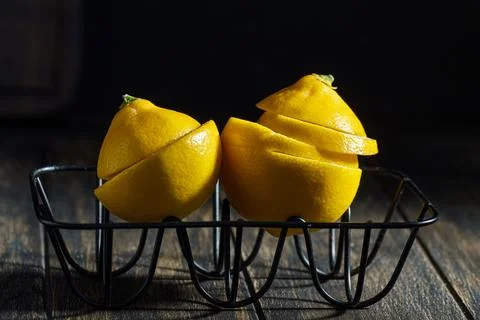 Two lemons side by side on wire rack have their peels cut into wedges Stockfoto's