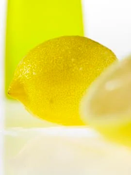Two Lemons sitting by a container Stock Photos