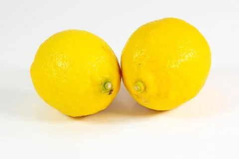 Two lemons on a white kitchen counter waiting to be sliced Stock Photos